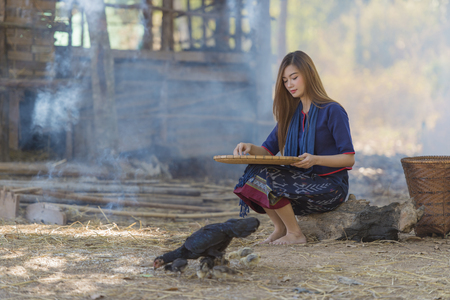 Asian beautiful girl winnowing rice separate between rice and rice huskの写真素材