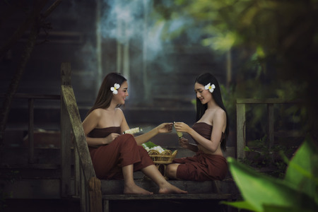 Thailand women in traditional dress sitting for made of flower garlands.の写真素材