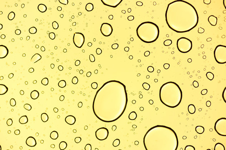 Drop of water on yellow light backgroundの写真素材