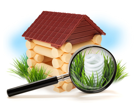 Energy saving fluorescent light bulb in wooden house under magnifying glassの写真素材