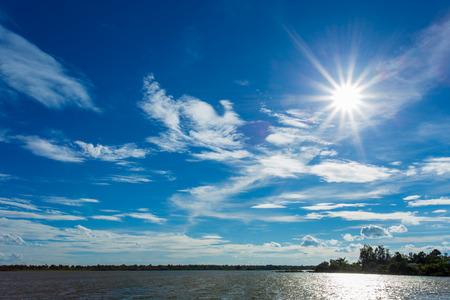 White clouds in dark blue sky background and water or riverの写真素材