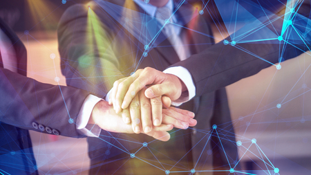 businessmen stack hands together in concept of business network unityの写真素材