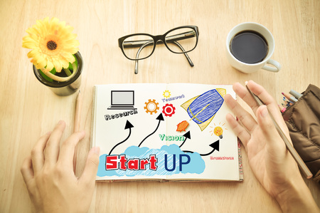 Businessman write Notebook word "Start up"の写真素材