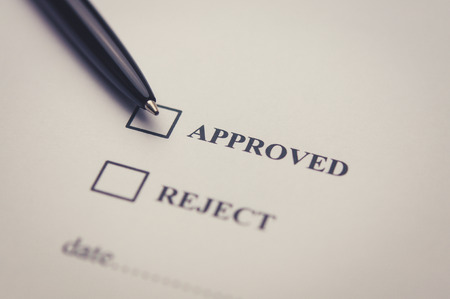 Approved and reject stamp with pen on white paperの写真素材
