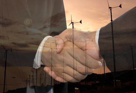 Double exposure business man handshake and wind energy industry concept.の写真素材