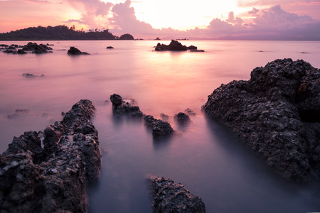 long exposure seascape with rock and sunset.の写真素材