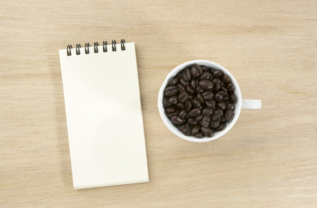 paper note with coffee bean in whith cup on woodenの写真素材