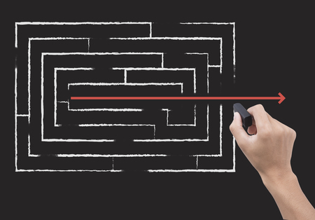 hand holding black eraser and maze. concept impossible to business possibleの写真素材
