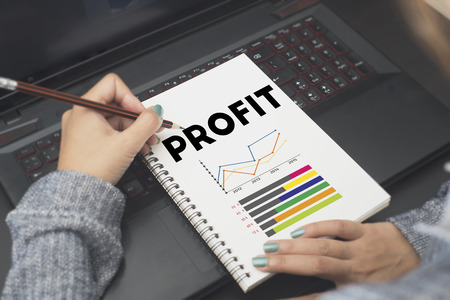 business hand writing Profit text on note book. benefit financial income growth concept.の写真素材