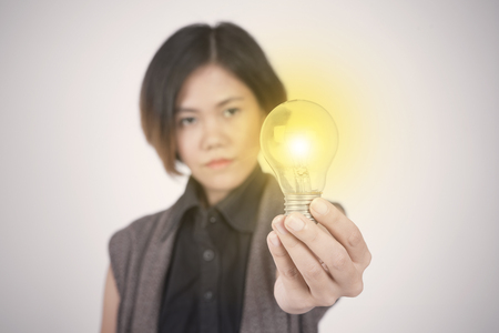 Business women hand holding light bulb, concept of new ideas with innovation and creativity.の写真素材