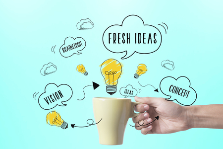 hand holding coffee cup with lightbulb. concept for new ideas with innovation and creativity.の写真素材