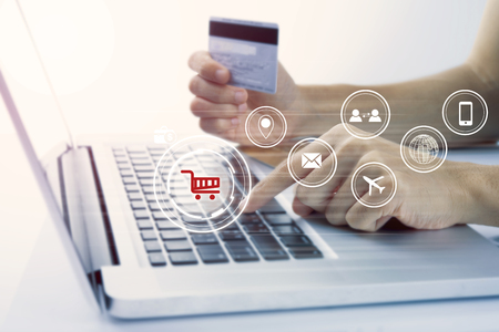 business hand holding credit card with computer and shopping online payment e-commerce internet technology concept.の写真素材