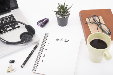 computer headset and coffee cup with to do list on desk from above, planning and schedule concept.の写真素材