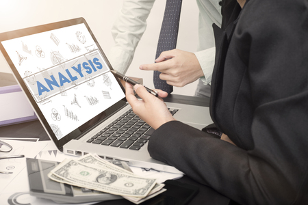 business hand point on a laptop with Analysis homepage on the computer screen finance and banking website web page concept.の写真素材