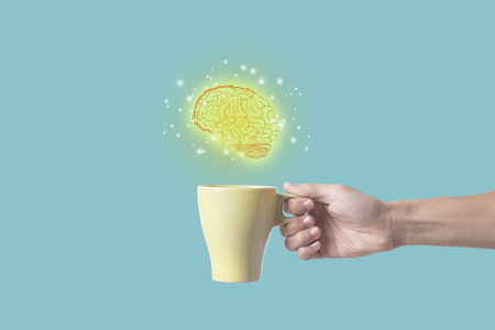 hand holding coffee cup with brain. concept for new ideas with innovation and creativity.