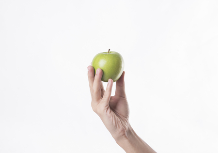 Hand holding fresh green apple isolated on white background.の写真素材