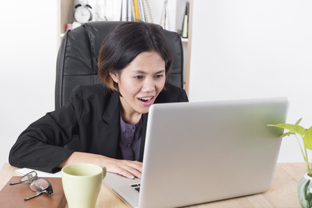 Asia businesswomen shocked look computer in office. concept surprise achievement.の写真素材