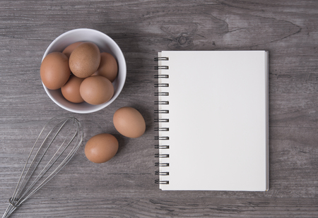 egg with open recipe book on wooden table, Top viewの写真素材