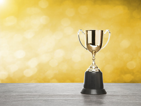 winner cup with gold bokeh background. copy space ready for product display montage.の写真素材