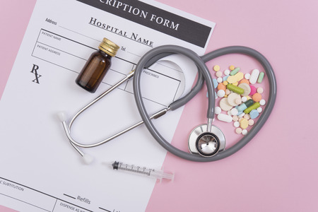 Pharmacy background on table. Stethoscope and prescription paper with colorful medicine.の写真素材