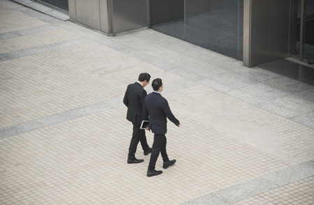 Business people having conversation and walking in office building. High angle viewの写真素材