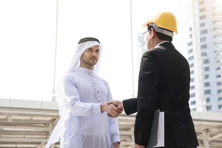 businessman arabic with engineer making handshake agreement. concept finishing up a meeting.の写真素材
