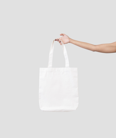 hand holding bag canvas fabric for mockup blank template isolated on gray background. の写真素材