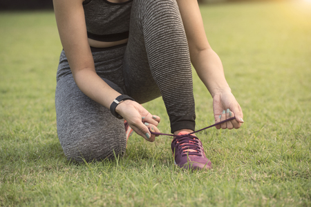 Runner women tie running shoes ready for jogging. Healthy lifestyle concept.の写真素材