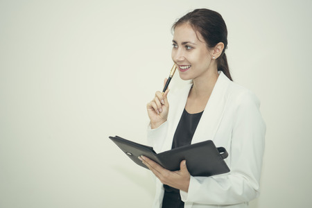 young businesswoman holding note book and thinking idea for work at office.の写真素材