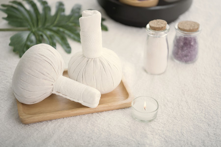 Spa accessories still life with aromatic candle, herb compress ball, orchid flower, salt and towel.の写真素材
