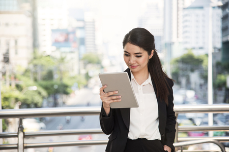 Happy asian businesswoman using a tablet computer.の写真素材