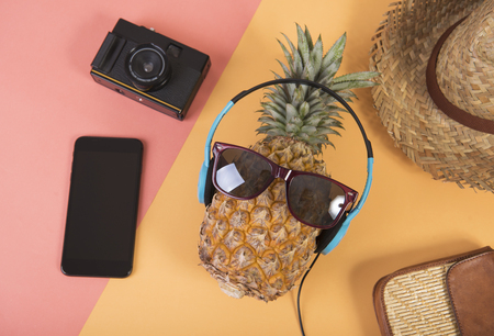 Pineapple with sunglasses and headphone on orange background. fruit summer concept.の写真素材
