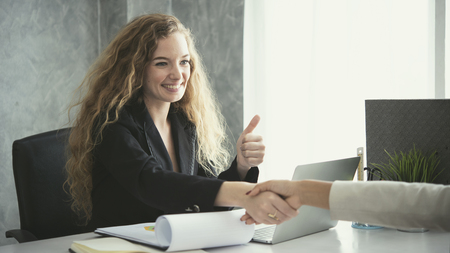 young business woman making handshake agreement and thumbs up together. concept teamwork and...