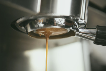 Barista using coffeemaker extraction for espresso shot in cafe.の写真素材
