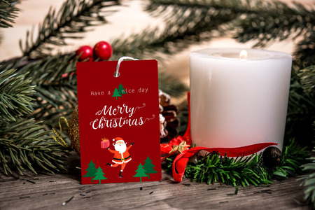 mockup tag paper card with candle christmas decoration on wood table background.の写真素材