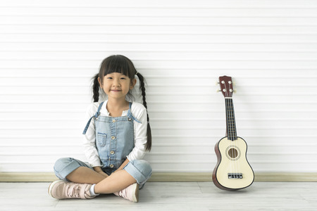 Little beautiful asian girl and guitaの写真素材