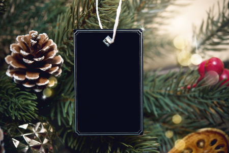 mockup tag paper card with pine cones christmas decoration on wood table background.の写真素材