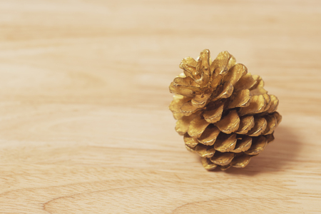 Golden pine cone decoration on wood table for Christmas and Happy new year.の写真素材