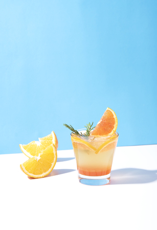 Cold and refreshing orange punch cocktail with orange slice on blue background. summer drink.の写真素材