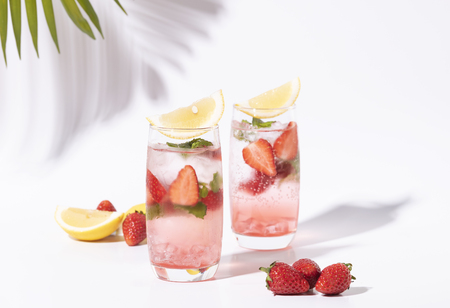 iced strawberry punch cocktail in glass with lemon on white background. summer drink.の写真素材