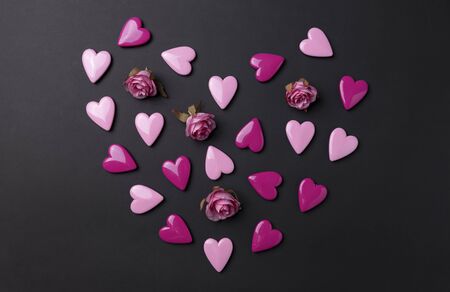 Valentines day background with red hearts and rose on black background.