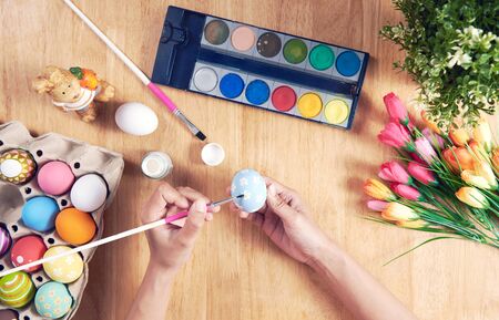 Happy easter, people painting Easter eggs on wooden rustic table for your decoration in holiday.