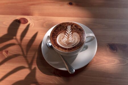 latte or Cappuccino with frothy foam, coffee cup top view on table in cafe.