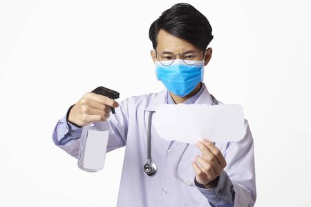 Asia doctor using spray alcohol cleaning mockup paper for protect anti virus bacteria.の写真素材