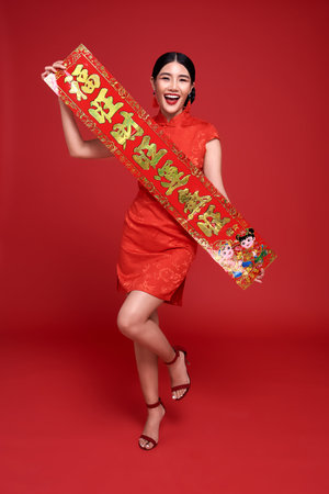 Happy Chinese new year. Asian woman wearing traditional cheongsam qipao dress holding Chinese New...