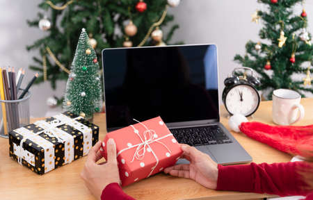 business woman holding giftbox on office table in Christmas day.の写真素材