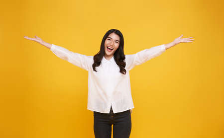 Happy young Asian teenage girl  isolated on yellow background.の写真素材