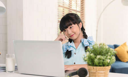 Asian girl using Laptop computer for online study homeschooling during home quarantine. online...