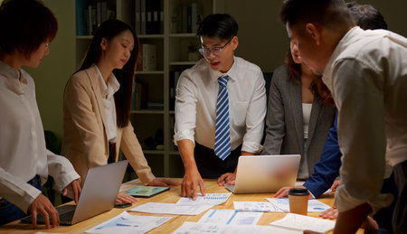 Group of Asia business people discussing business brainstorming meeting ideas strategy in night...