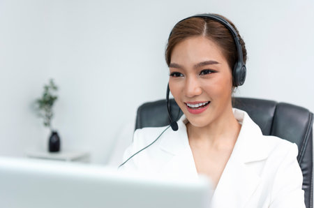 Asian woman Call center agent with headset working on support hotline in modern office.の写真素材